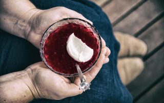 A bowl of Rote Grütze with a dollop of fresh cream
